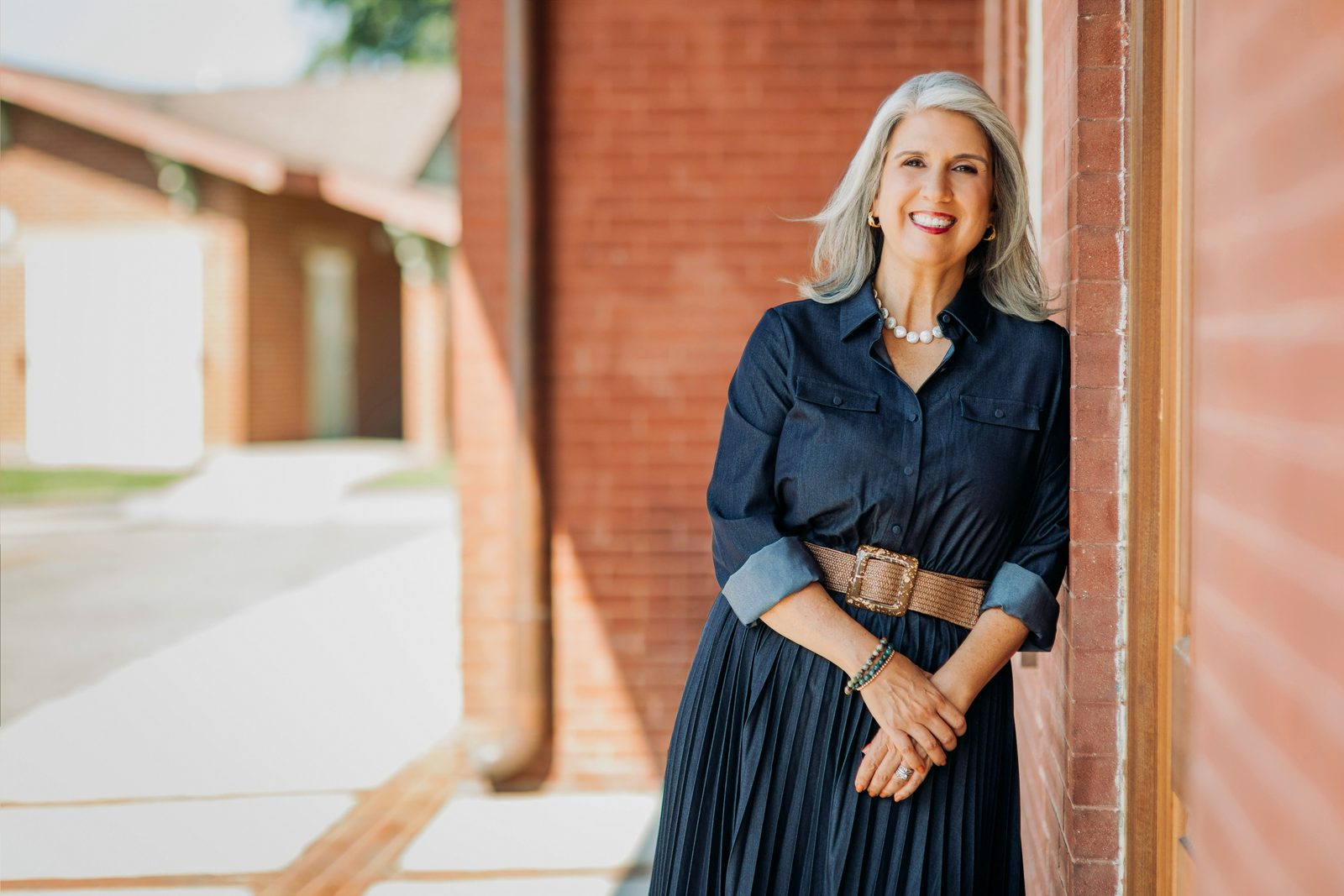 April Montgomery leaning against a brick wall in downtown Sanford.